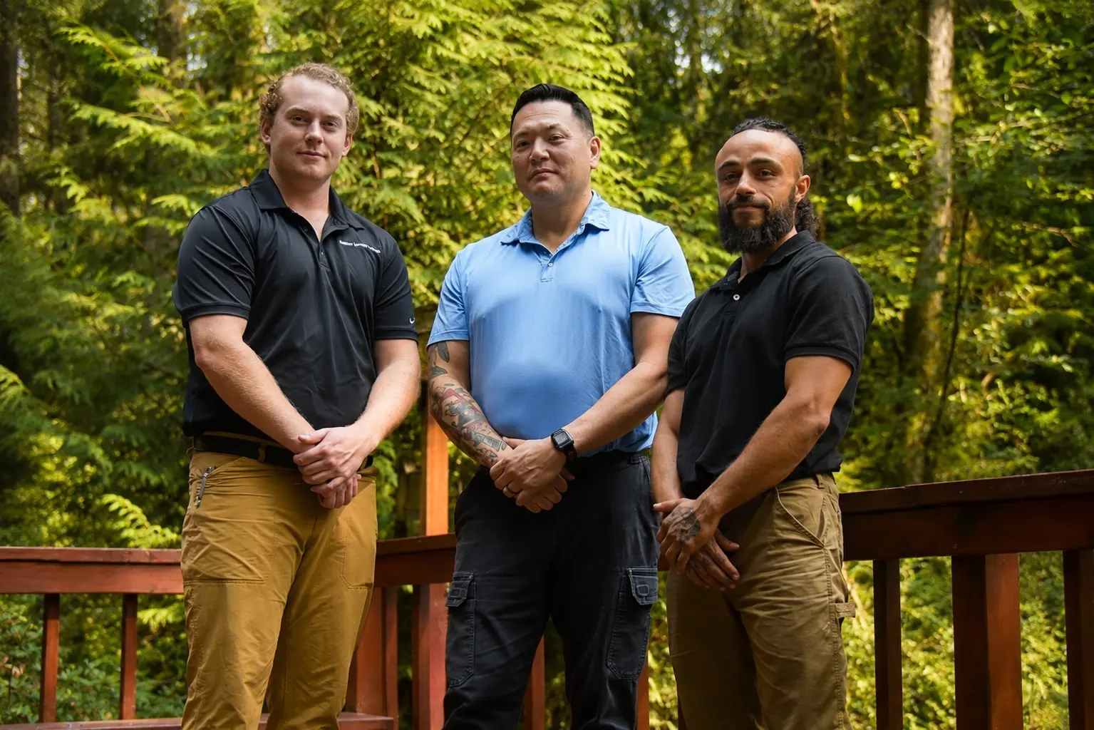 Rampart Restoration team members in black and blue polo shirts standing outdoors.